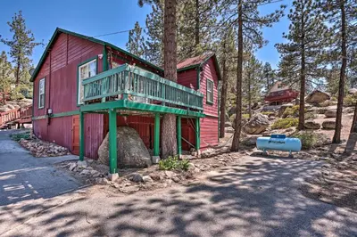 a red house with a balcony on the side of it at Big Bear Cabin Close to Lake, Trails and Village! in Big Bear Lake