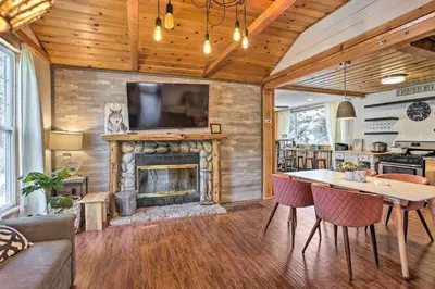 a living room with a fireplace and a table at Big Bear Cabin Close to Lake, Trails and Village! in Big Bear Lake