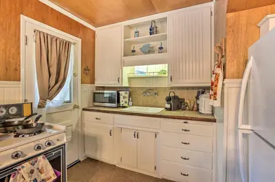 a kitchen with white cabinets and a white refrigerator at Cozy Crestline Cabin, Close to Lakes, Parks! in Crestline