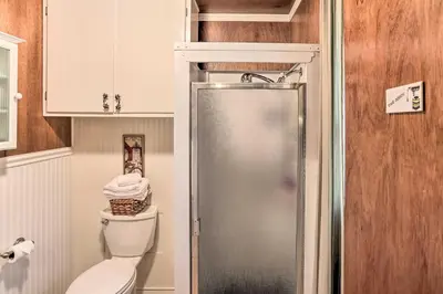 a small bathroom with a toilet and a shower at Cozy Crestline Cabin, Close to Lakes, Parks! in Crestline