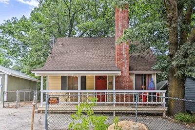 a house with a porch with a flag on it at Cozy Crestline Cabin, Close to Lakes, Parks! in Crestline