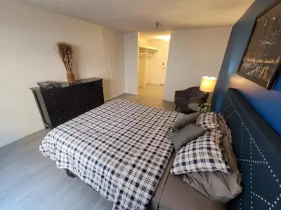 a bedroom with a bed with a checkered blanket at Deluxe Hotel Style Unit in Los Angeles