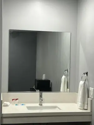 a bathroom with a sink and a large mirror at Sunshine Motel in Long Beach