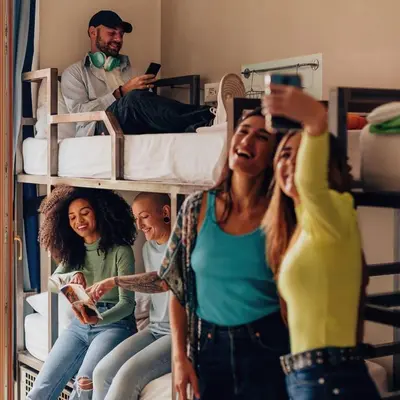 a group of people sitting on a bunk bed at Bposhtels Anaheim in Anaheim