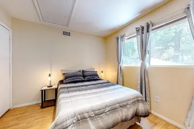 a bedroom with a bed and a large window at Treelands Lodge in Crestline