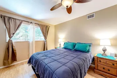 a bedroom with a blue bed and a ceiling fan at Treelands Lodge in Crestline