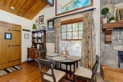a dining room with a table and a window at Treetop Cottage in Running Springs