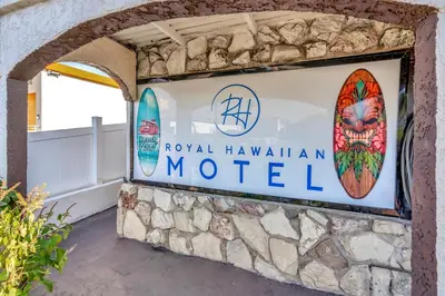 a sign for the hotel hawaiian motel with two surfboards at Royal Hawaiian Inn - Mid City, Los Angeles in Los Angeles