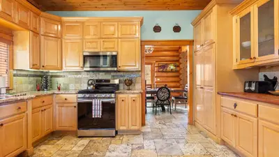a kitchen with wooden cabinets and a stove top oven at 0.5mi to the Lake Deck w Views Poker Table Eagle Ridge Retreat by AvantStay in Big Bear Lake