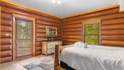 a bedroom with a bed in a room with wooden walls at 0.5mi to the Lake Deck w Views Poker Table Eagle Ridge Retreat by AvantStay in Big Bear Lake
