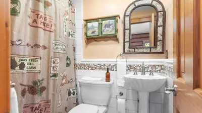 a bathroom with a toilet and a sink and a mirror at 0.5mi to the Lake Deck w Views Poker Table Eagle Ridge Retreat by AvantStay in Big Bear Lake