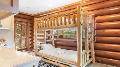 a bedroom with a bunk bed in a log cabin at 0.5mi to the Lake Deck w Views Poker Table Eagle Ridge Retreat by AvantStay in Big Bear Lake