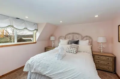 a bedroom with a white bed and a window at Lakefront Estate w Private Dock HotTub FirePit Lagunita Shores by AvantStay in Big Bear Lake