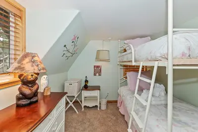 a bedroom with bunk beds and a desk with a lamp at Lakefront Estate w Private Dock HotTub FirePit Lagunita Shores by AvantStay in Big Bear Lake