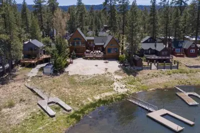 an aerial view of a large house with a lake at Lakefront Estate w Private Dock HotTub FirePit Lagunita Shores by AvantStay in Big Bear Lake