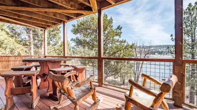 a large screened porch with tables and chairs and a view at Lakefront Lodge by AvantStay Direct Access to Big Bear Lake Hot Tub Views in Big Bear Lake