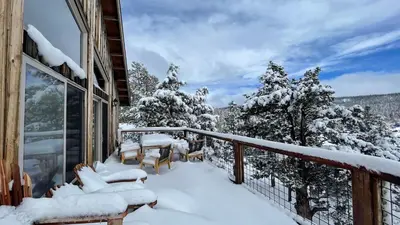 a balcony covered in snow with chairs and tables at Lakefront Lodge by AvantStay Direct Access to Big Bear Lake Hot Tub Views in Big Bear Lake