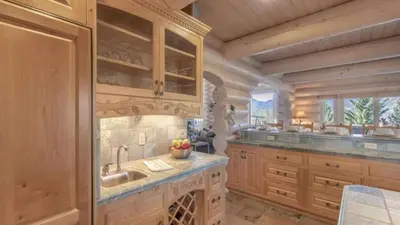 a large kitchen with wooden cabinets and a sink at Hot Tub Game Room Large Deck w Incredible View Penticton Lodge by AvantStay in Big Bear Lake