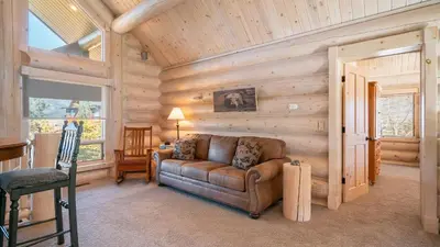 a living room with a couch in a room with wooden walls at Hot Tub Game Room Large Deck w Incredible View Penticton Lodge by AvantStay in Big Bear Lake