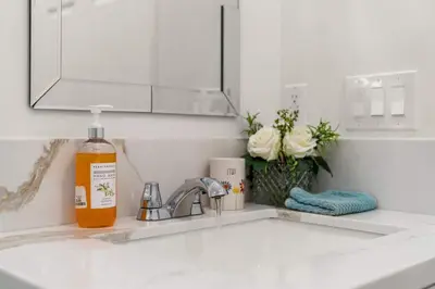 a bottle of orange liquid sitting on a kitchen sink at The Avalon - 35 Percent Off March! in Los Angeles