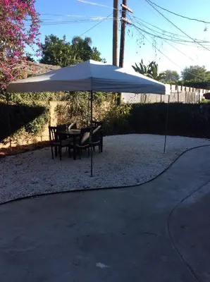 a table and chairs under a white umbrella at Modern spacious home close to Universal studio & Hollywood for 11 in Los Angeles