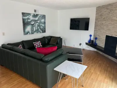 a living room with a green couch and a table at Modern spacious home close to Universal studio & Hollywood for 11 in Los Angeles