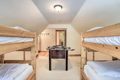 a room with two bunk beds and a table at Spacious Lake Arrowhead Home with Putting Green in Lake Arrowhead