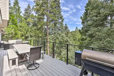 a deck with a grill and a table and chairs at Spacious Lake Arrowhead Home with Putting Green in Lake Arrowhead
