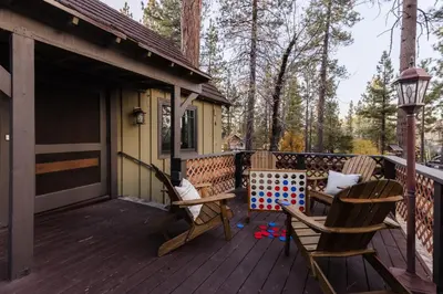 a wooden deck with two chairs and a table at Walk to the Lake Sand Volleyball Court Pool Table Deck Gambler by AvantStay in Big Bear Lake