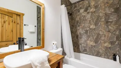 a bathroom with a tub and a toilet and a sink at Teddy by AvantStay Majestic Cabin in Big Bear w Balcony in Big Bear Lake