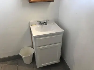 a bathroom with a white sink and a trash can at King Castle Motel in Los Angeles