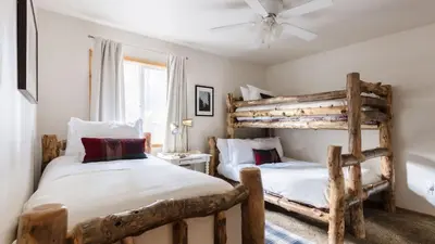 two beds in a bedroom with wooden bunk beds at Jackhorn by AvantStay Close to Big Bear Marina and Village Hot Tub Foosball in Big Bear Lake