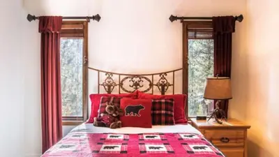a bedroom with a bed with red pillows at Big Bear Castle by AvantStay Private Home in Great Big Bear Location w Hot Tub in Big Bear Lake