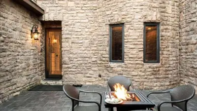 a patio with a table and chairs with a fire at Big Bear Castle by AvantStay Private Home in Great Big Bear Location w Hot Tub in Big Bear Lake