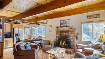 a living room with a fireplace and a table at 50 yards to Lake Boulder Bay • Pool Table Lakeside in Bearadise by AvantStay in Big Bear Lake