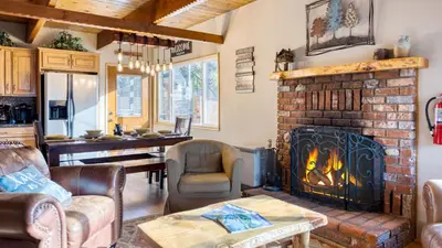 a living room with a fireplace and a table at 50 yards to Lake Boulder Bay • Pool Table Lakeside in Bearadise by AvantStay in Big Bear Lake
