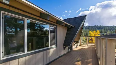 a house with a wooden deck with windows on it at 50 yards to Lake Boulder Bay • Pool Table Lakeside in Bearadise by AvantStay in Big Bear Lake