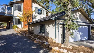 a white house with a garage and a tree at 50 yards to Lake Boulder Bay • Pool Table Lakeside in Bearadise by AvantStay in Big Bear Lake
