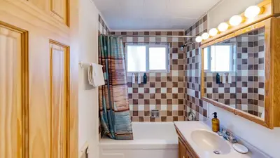 a bathroom with a tub and a sink and a mirror at 50 yards to Lake Boulder Bay • Pool Table Lakeside in Bearadise by AvantStay in Big Bear Lake