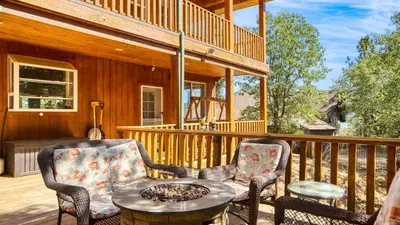 a patio with two chairs and a table on a deck at Zen Den by AvantStay Entertainers Home in Ideal Big Bear Location w Hot Tub in Big Bear Lake