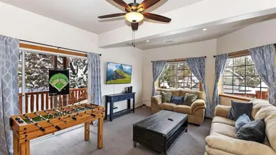 a living room with a foosball table in the middle at Zen Den by AvantStay Entertainers Home in Ideal Big Bear Location w Hot Tub in Big Bear Lake