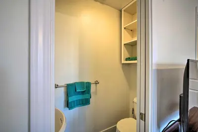a bathroom with a toilet and a blue towel at Relaxing Lake Arrowhead Home about 1 Mi to Lake! in Lake Arrowhead