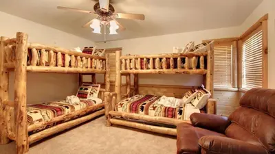 a bedroom with two bunk beds and a couch at Starlight Retreat by AvantStay Gorgeous Log Style Home w Incredible Views in Big Bear Lake