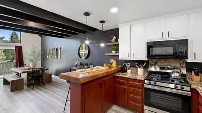 a kitchen with white cabinets and a counter top at Hot Tub Fire Pit Deck Views Near the Lake The Matterhorn Manor by AvantStay in Crestline