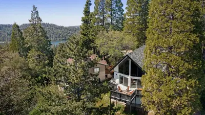 an aerial view of a house in the trees at Hot Tub Fire Pit Deck Views Near the Lake The Matterhorn Manor by AvantStay in Crestline
