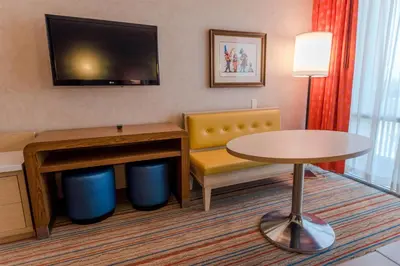 a hotel room with a table and a chair and a tv at Howard Johnson by Wyndham Anaheim Hotel and Water Playground in Anaheim