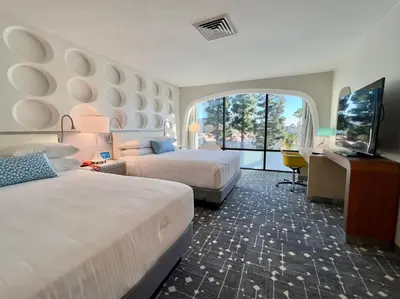a hotel room with two beds and a television at Howard Johnson by Wyndham Anaheim Hotel and Water Playground in Anaheim