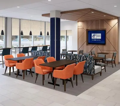 a restaurant with tables and chairs and a tv at Holiday Inn Express & Suites Ridgecrest - China Lake by IHG in Ridgecrest