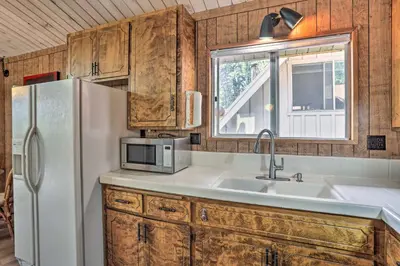 a kitchen with a white refrigerator and a sink at Lake Arrowhead Cabin with Mid-Century Charm! in Lake Arrowhead