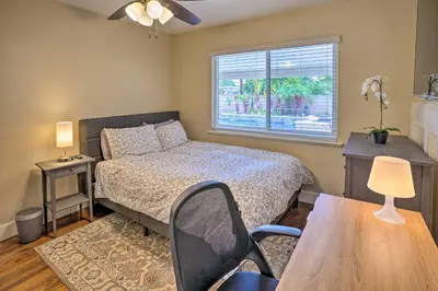 a bedroom with a bed and a table and a window at Quiet Anaheim Home with Pool, 5 Mi to Disney! in Anaheim